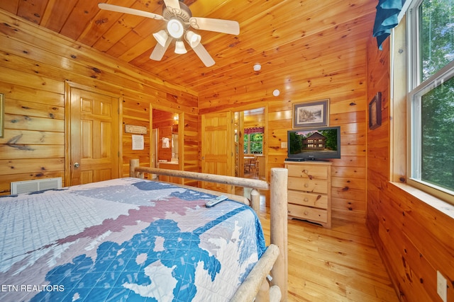 bedroom with light wood finished floors, wooden walls, wooden ceiling, and a ceiling fan