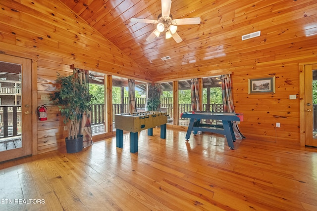 playroom with vaulted ceiling, light wood-style floors, wood walls, ceiling fan, and wooden ceiling
