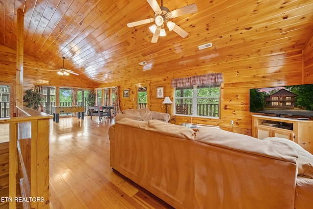 living room with ceiling fan, wooden walls, healthy amount of natural light, light wood-style floors, and wooden ceiling