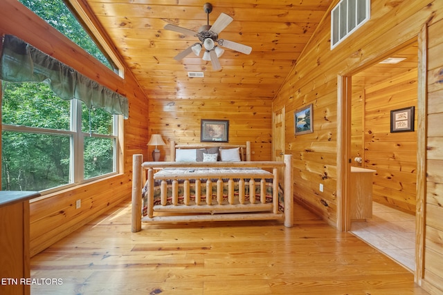 bedroom featuring vaulted ceiling, wooden walls, light wood-style floors, and wooden ceiling