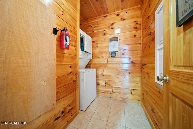 washroom with stacked washer / dryer, light tile patterned floors, wood walls, and wooden ceiling