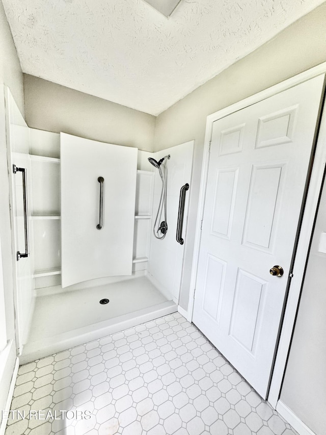 200 Harmon Cir, New Tazewell, TN 37825 - full bath with tile patterned floors, a shower stall, a textured ceiling, and baseboards