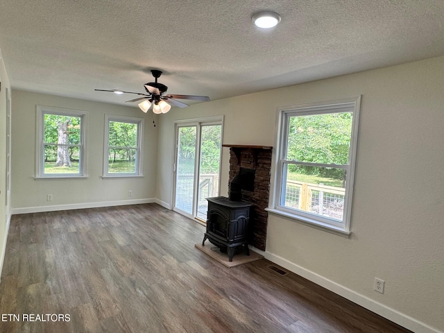 4540 S York Hwy, Jamestown, TN 38556 - unfurnished living room featuring a wood stove, a textured ceiling, healthy amount of natural light, and wood finished floors