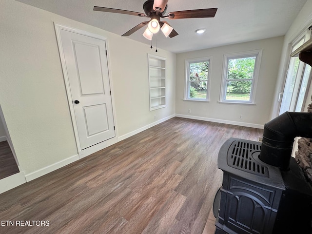 4540 S York Hwy, Jamestown, TN 38556 - living area featuring ceiling fan, wood finished floors, a wood stove, baseboards, and built in shelves