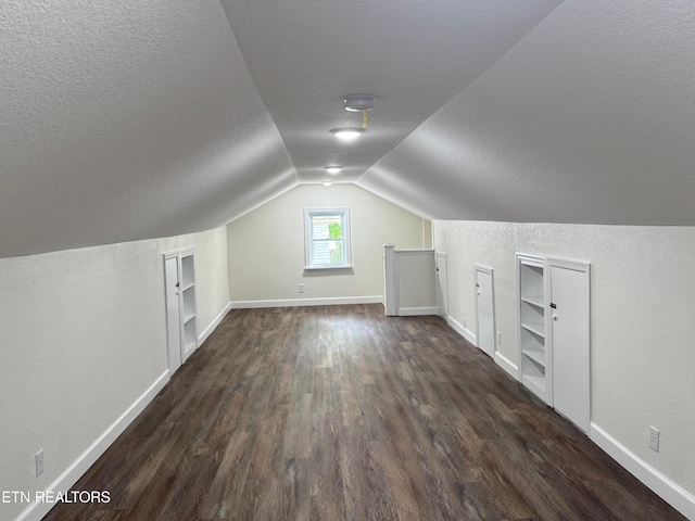 4540 S York Hwy, Jamestown, TN 38556 - additional living space with dark wood-style floors, a textured ceiling, built in features, baseboards, and lofted ceiling