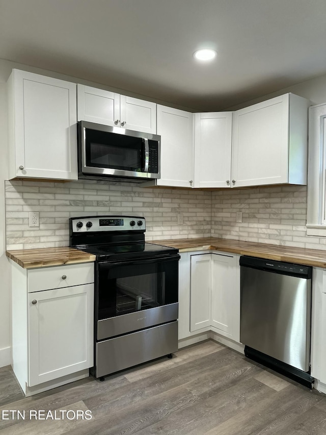 3824 Catalpa Ave, Knoxville, TN 37914 - kitchen with wood counters, stainless steel appliances, light wood finished floors, white cabinets, and recessed lighting