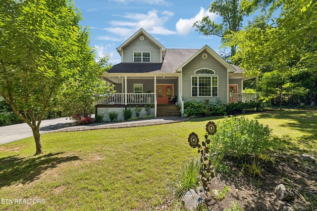221 Stony Rock Ln, Jacksboro, TN 37757 - traditional-style house with covered porch, a front yard, a shingled roof, concrete driveway, and french doors