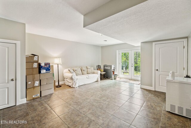 221 Stony Rock Ln, Jacksboro, TN 37757 - living area featuring a textured ceiling, french doors, tile patterned floors, and baseboards
