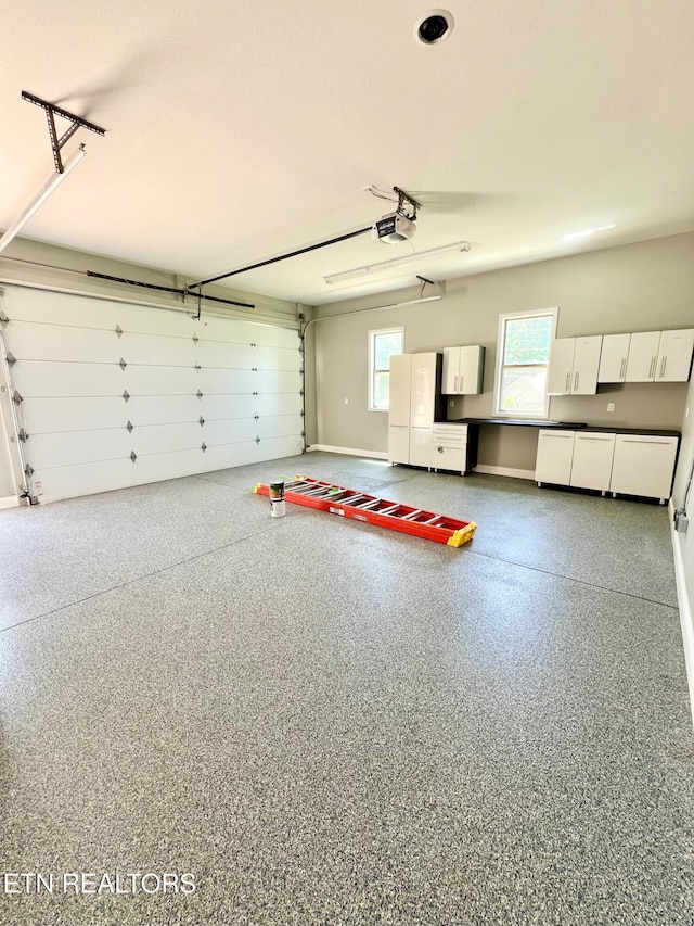 129 Canary Ct, Crossville, TN 38555 - garage with a garage door opener, baseboards, and freestanding refrigerator