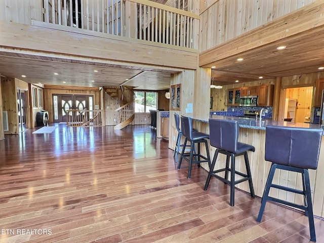 189 Bridle Way, Speedwell, TN 37870 - kitchen with appliances with stainless steel finishes, wooden walls, open floor plan, wood finished floors, and a high ceiling