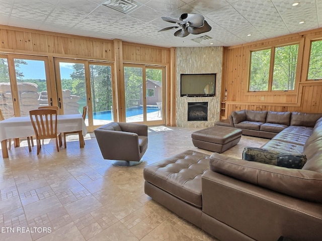 189 Bridle Way, Speedwell, TN 37870 - living area featuring wooden walls, a ceiling fan, plenty of natural light, and a fireplace