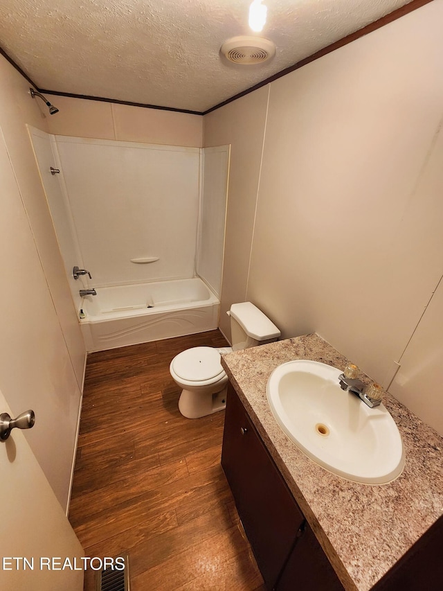 334 Corrington Ln, Lafollette, TN 37766 - bathroom featuring wood finished floors, a textured ceiling, toilet, vanity, and bathing tub / shower combination