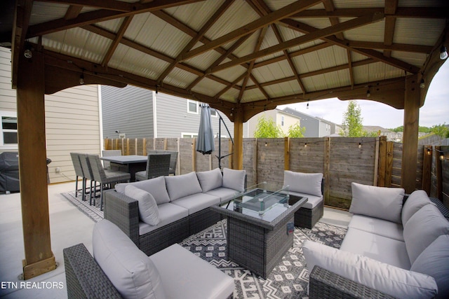 view of patio with an outdoor living space, a gazebo, a fenced backyard, and a grill