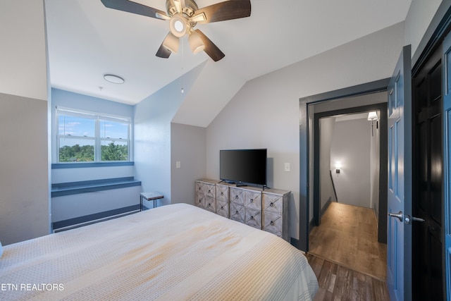 bedroom with dark wood-style floors, lofted ceiling, and ceiling fan