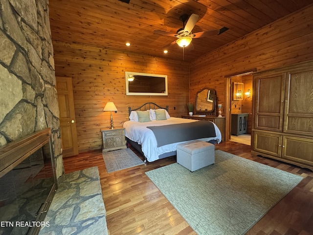 1186 Deerfield Way, Lafollette, TN 37766 - bedroom with wood finished floors, wooden ceiling, wooden walls, ensuite bathroom, and a stone fireplace