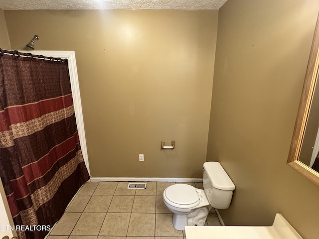 211 Jamie St, Maynardville, TN 37807 - full bath with tile patterned flooring, a textured ceiling, toilet, a shower with curtain, and baseboards