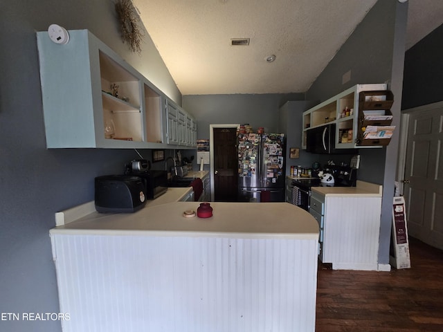 291 Tall Oaks Dr, Pennington Gap, VA 24277 - kitchen with freestanding refrigerator, open shelves, black microwave, dark wood finished floors, and lofted ceiling