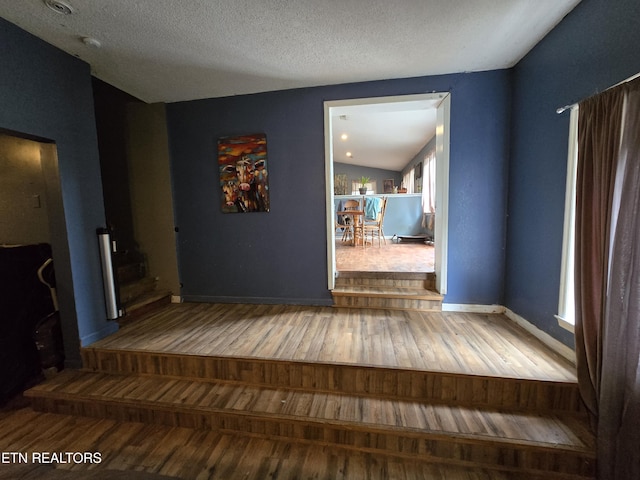 291 Tall Oaks Dr, Pennington Gap, VA 24277 - hall featuring wood finished floors, lofted ceiling, a textured ceiling, and baseboards