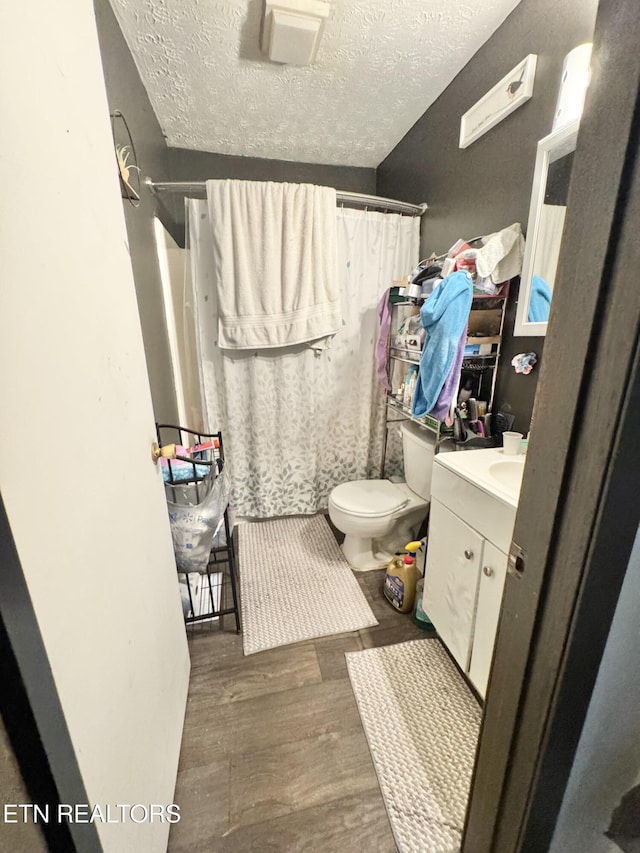 108 E Hunter Cir, Oak Ridge, TN 37830 - bathroom featuring wood finished floors, vanity, a textured ceiling, toilet, and curtained shower