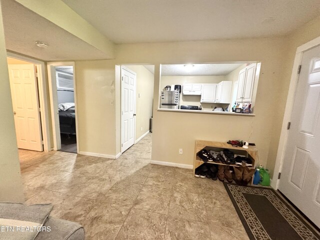 108 E Hunter Cir, Oak Ridge, TN 37830 - kitchen featuring white cabinetry, baseboards, and a peninsula