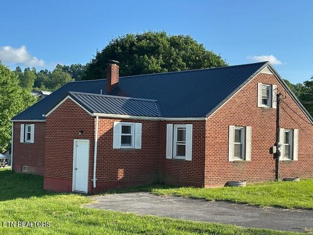 156 Beatty Rd, Rose Hill, VA 24281 - back of house featuring a chimney, brick siding, metal roof, a yard, and a standing seam roof