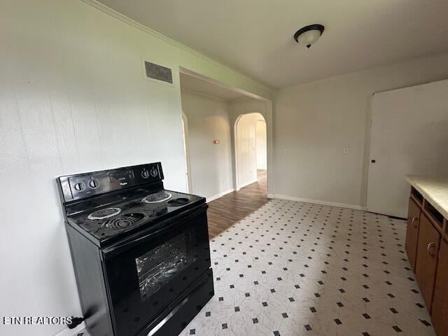 156 Beatty Rd, Rose Hill, VA 24281 - kitchen with black range with electric cooktop, arched walkways, light floors, light countertops, and baseboards