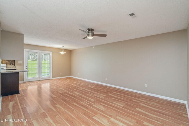 1051 Nod St, Knoxville, TN 37932 - unfurnished living room featuring ceiling fan, light wood finished floors, baseboards, and a textured ceiling