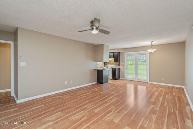 1051 Nod St, Knoxville, TN 37932 - unfurnished living room featuring light wood finished floors, baseboards, ceiling fan, and a textured ceiling