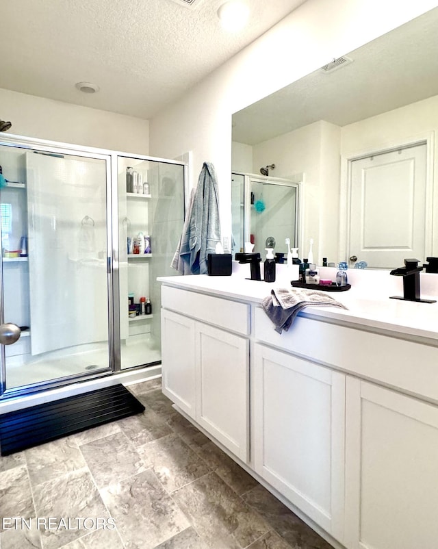 1013 Curly Top Ln, Knoxville, TN 37932 - full bathroom featuring double vanity, a stall shower, a textured ceiling, and stone finish floors