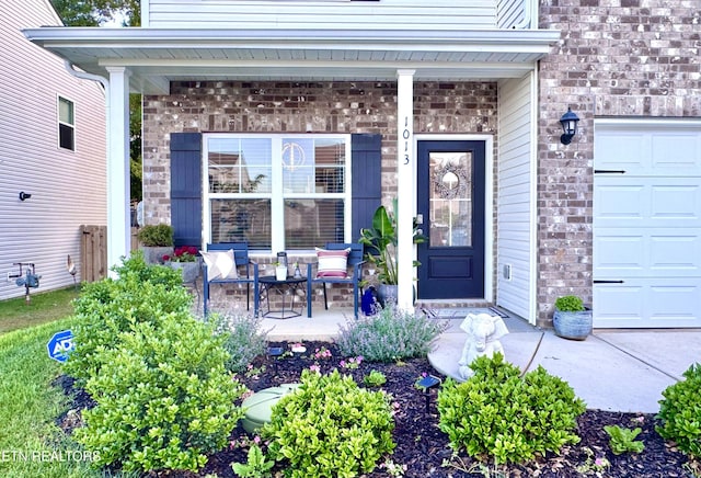 1013 Curly Top Ln, Knoxville, TN 37932 - doorway to property featuring a porch, a garage, and brick siding