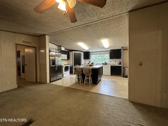 214 Hickory Grove Rd, Madisonville, TN 37354 - kitchen with white appliances, dark cabinets, light countertops, a kitchen breakfast bar, and ceiling fan