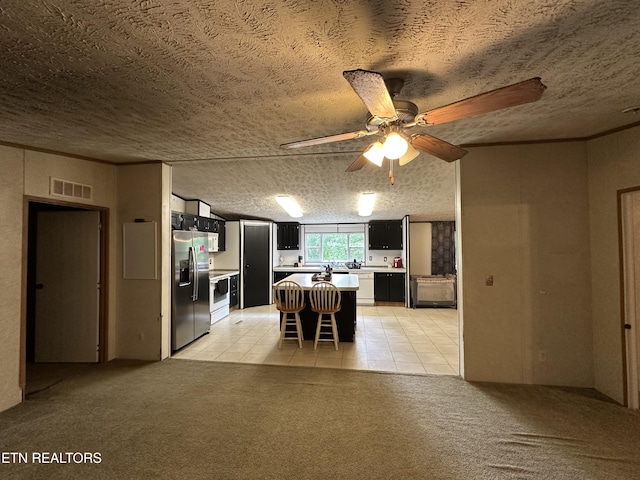 214 Hickory Grove Rd, Madisonville, TN 37354 - dining room featuring a textured ceiling, light tile patterned floors, light colored carpet, and ceiling fan
