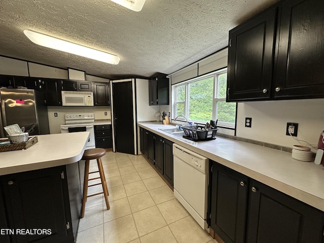 214 Hickory Grove Rd, Madisonville, TN 37354 - kitchen featuring white appliances, dark cabinets, a sink, light countertops, and vaulted ceiling