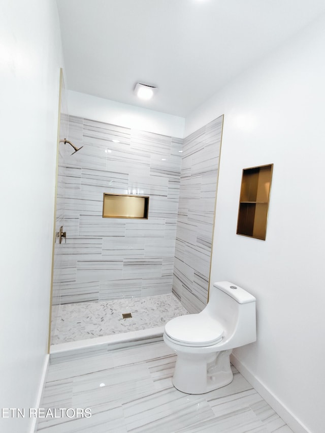 2714 E 5th Ave, Knoxville, TN 37914 - bathroom with toilet, tiled shower, and baseboards