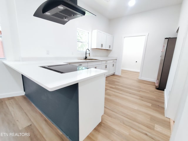 2714 E 5th Ave, Knoxville, TN 37914 - kitchen featuring freestanding refrigerator, black electric cooktop, extractor fan, and light wood-type flooring