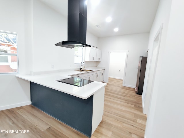 2714 E 5th Ave, Knoxville, TN 37914 - kitchen with island exhaust hood, a sink, black electric stovetop, freestanding refrigerator, and white cabinetry