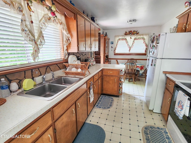 1711 Rocky Branch Rd, Rutledge, TN 37861 - kitchen featuring light flooring, brown cabinetry, light countertops, a sink, and tasteful backsplash