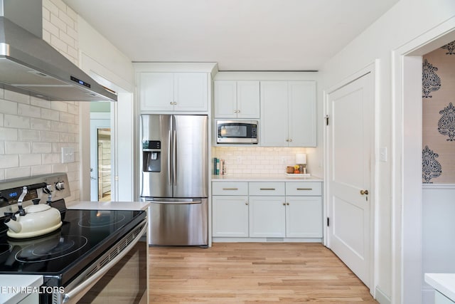 4051 Sutherland Ave, Knoxville, TN 37919 - kitchen featuring stainless steel appliances, wall chimney exhaust hood, light wood-style flooring, white cabinetry, and light countertops
