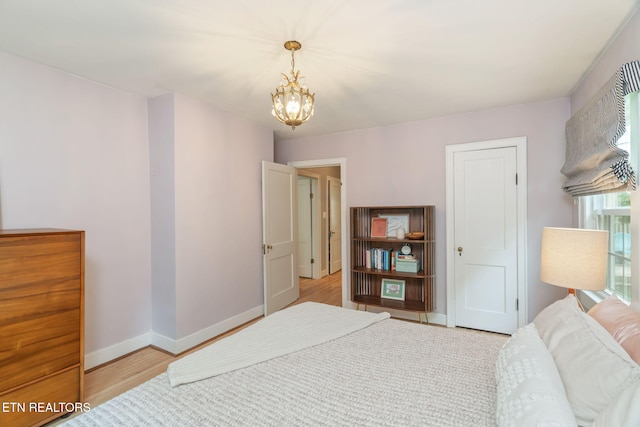 4051 Sutherland Ave, Knoxville, TN 37919 - bedroom featuring a chandelier, light wood-style flooring, and baseboards