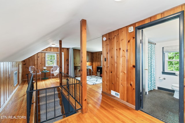 4051 Sutherland Ave, Knoxville, TN 37919 - hallway with an upstairs landing, light wood-style flooring, wood walls, baseboards, and vaulted ceiling