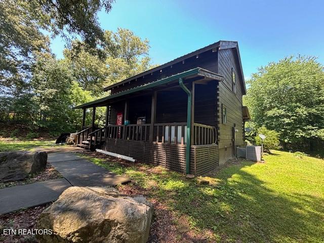 208 Charles Eaves Ln, Benton, TN 37307 - view of property exterior featuring a porch, a lawn, and central AC