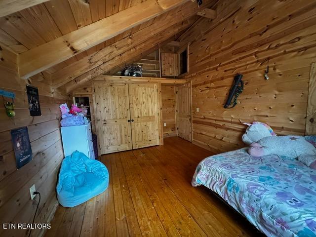 208 Charles Eaves Ln, Benton, TN 37307 - bedroom with wooden walls, hardwood / wood-style floors, lofted ceiling, and wood ceiling