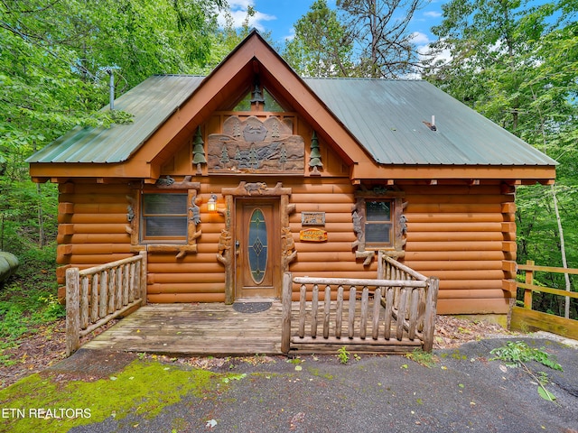 log cabin featuring log exterior and metal roof
