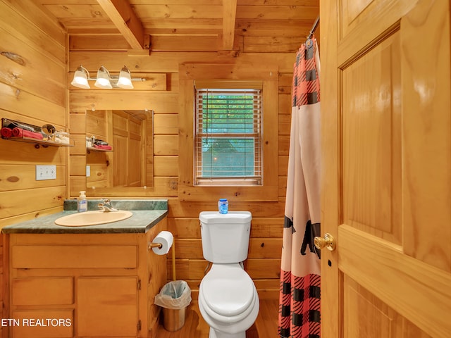 bathroom featuring wood walls, wooden ceiling with exposed beams, toilet, vanity, and curtained shower