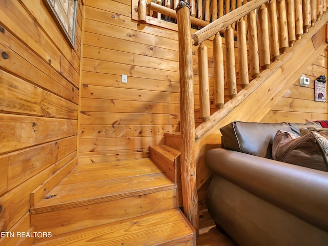 staircase featuring a sauna / steam room and wooden walls