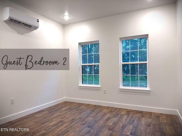 1146 Moodyville Loop, Byrdstown, TN 38549 - unfurnished room featuring a wall unit AC, dark wood-style floors, and plenty of natural light