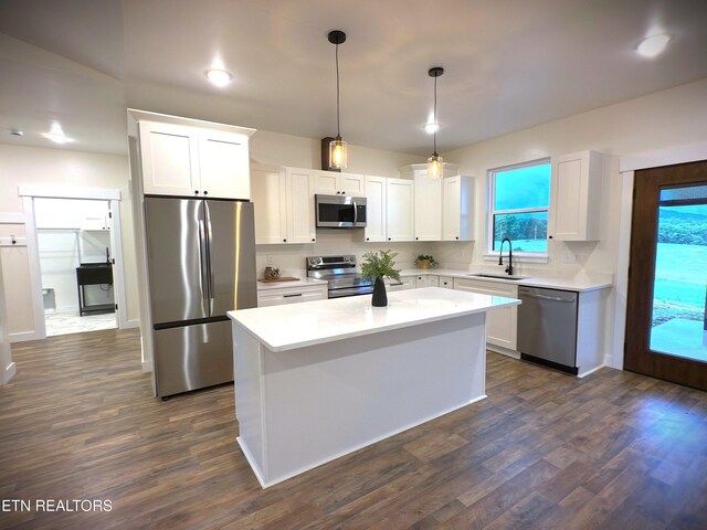 1146 Moodyville Loop, Byrdstown, TN 38549 - kitchen with stainless steel appliances, white cabinets, light countertops, a kitchen island, and dark wood-style floors