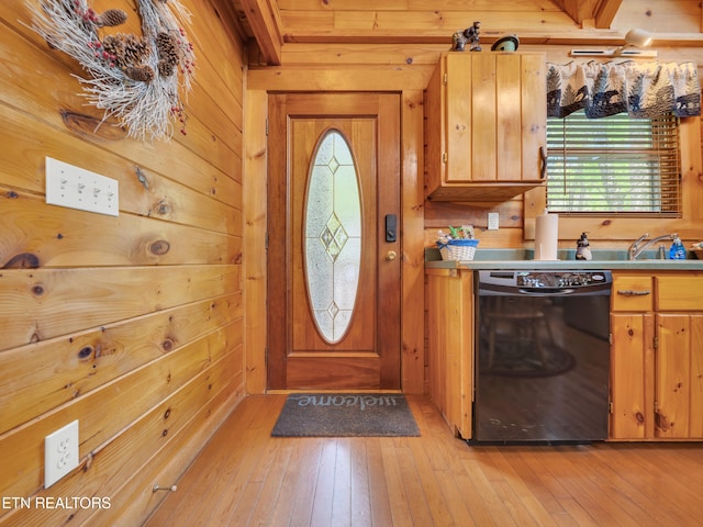 kitchen featuring dishwasher, light wood finished floors, wood walls, and brown cabinetry