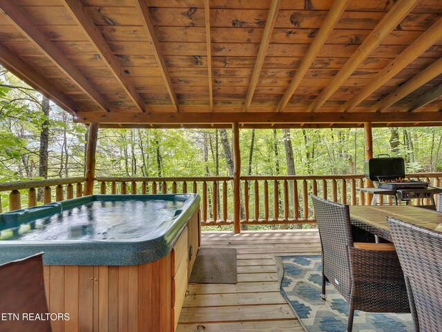 wooden deck featuring a hot tub and view of scattered trees
