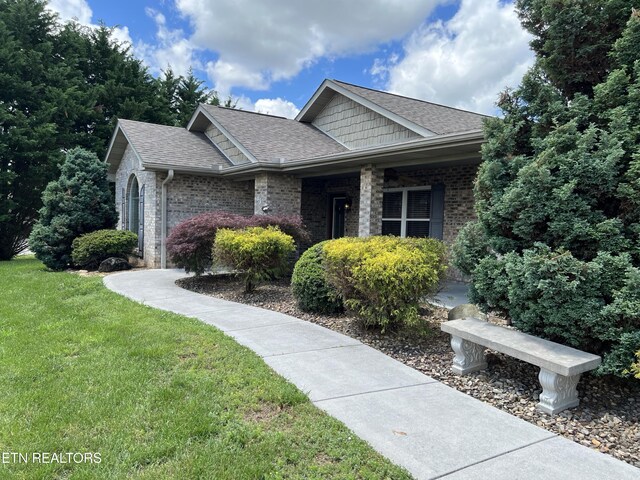 1018 Southwind Cir, Dandridge, TN 37725 - view of front of home with a front yard, a shingled roof, and brick siding